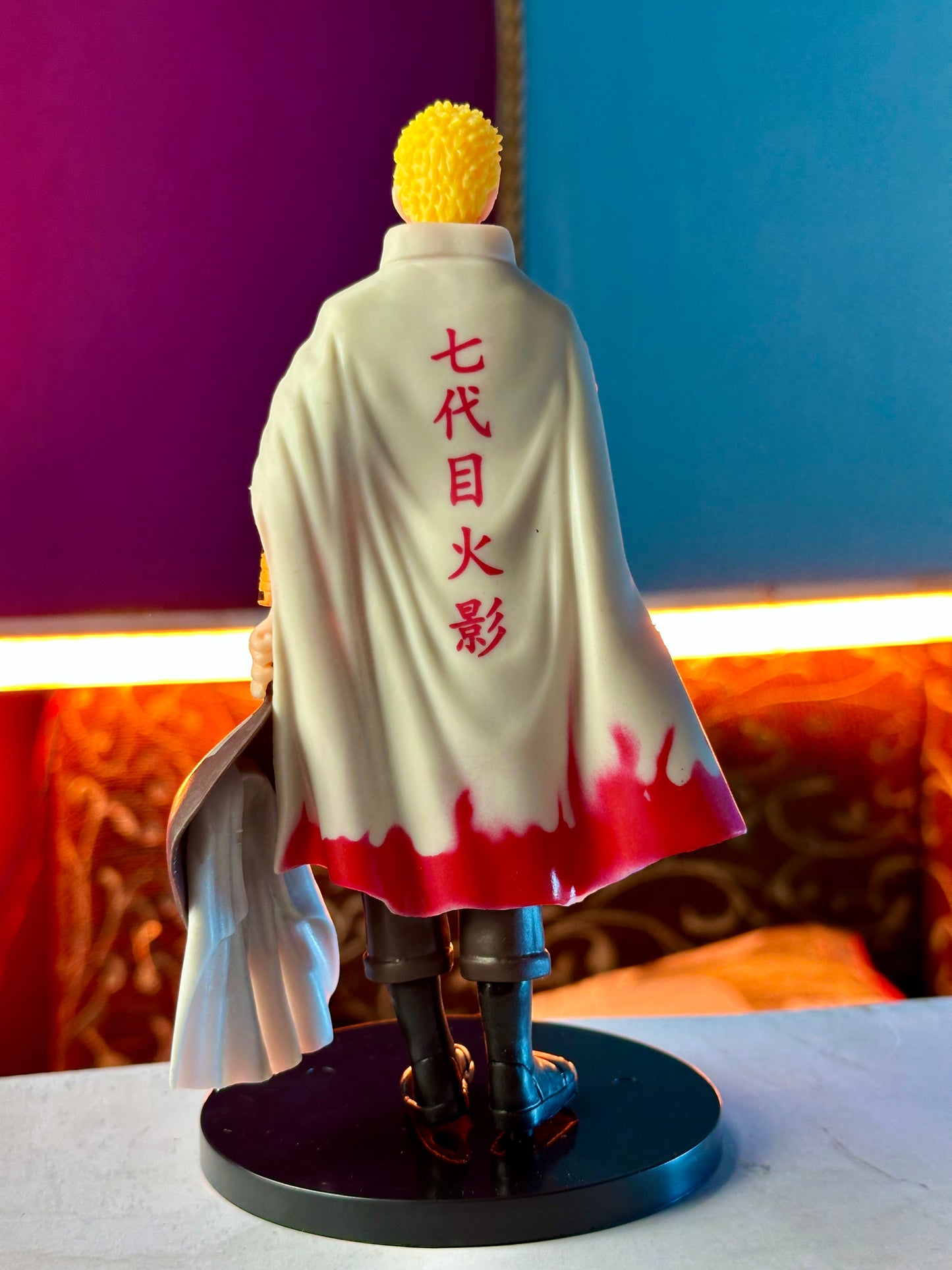 Adult Naruto Uzumaki figure wearing Hokage cloak standing on display base