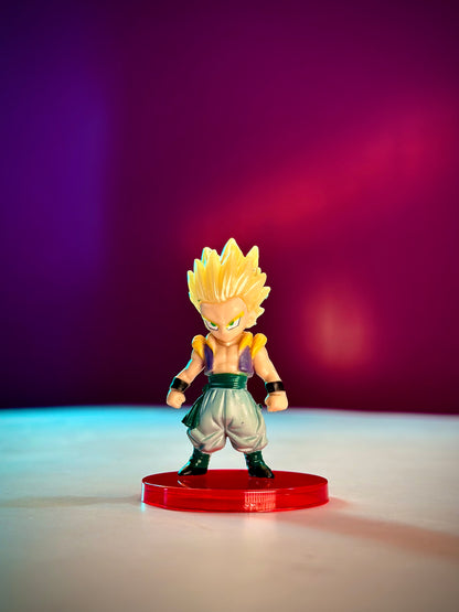 Super Saiyan character figurine on a red base against a gradient purple and pink background