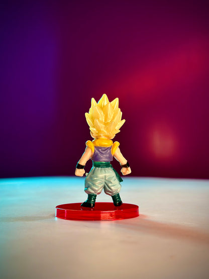 Super Saiyan figure on a red base against a gradient purple to pink background