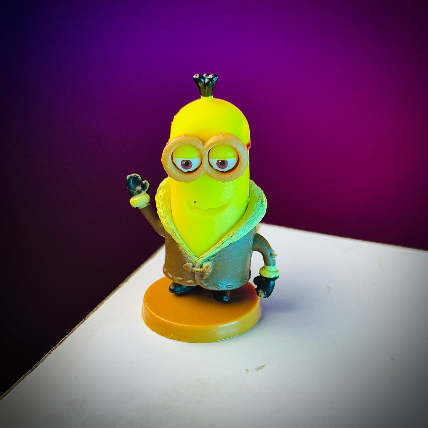 Toy figure of a character with a yellow head and green body on a purple background