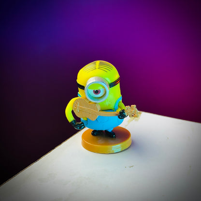 Minion toy figure holding a guitar on a purple and white background