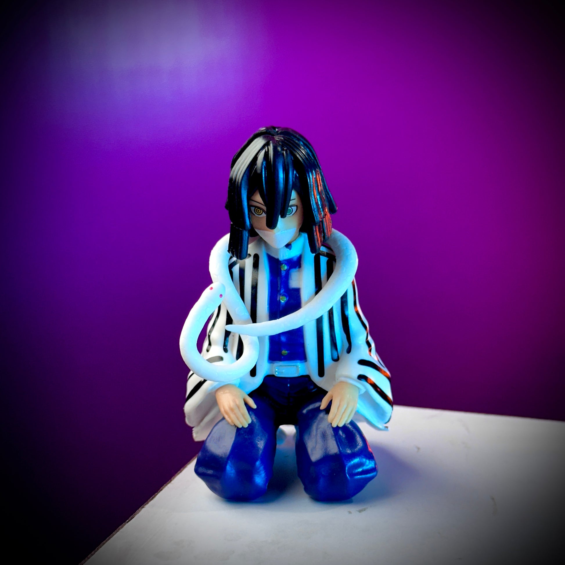 Figurine with blue hair and striped outfit against a purple background