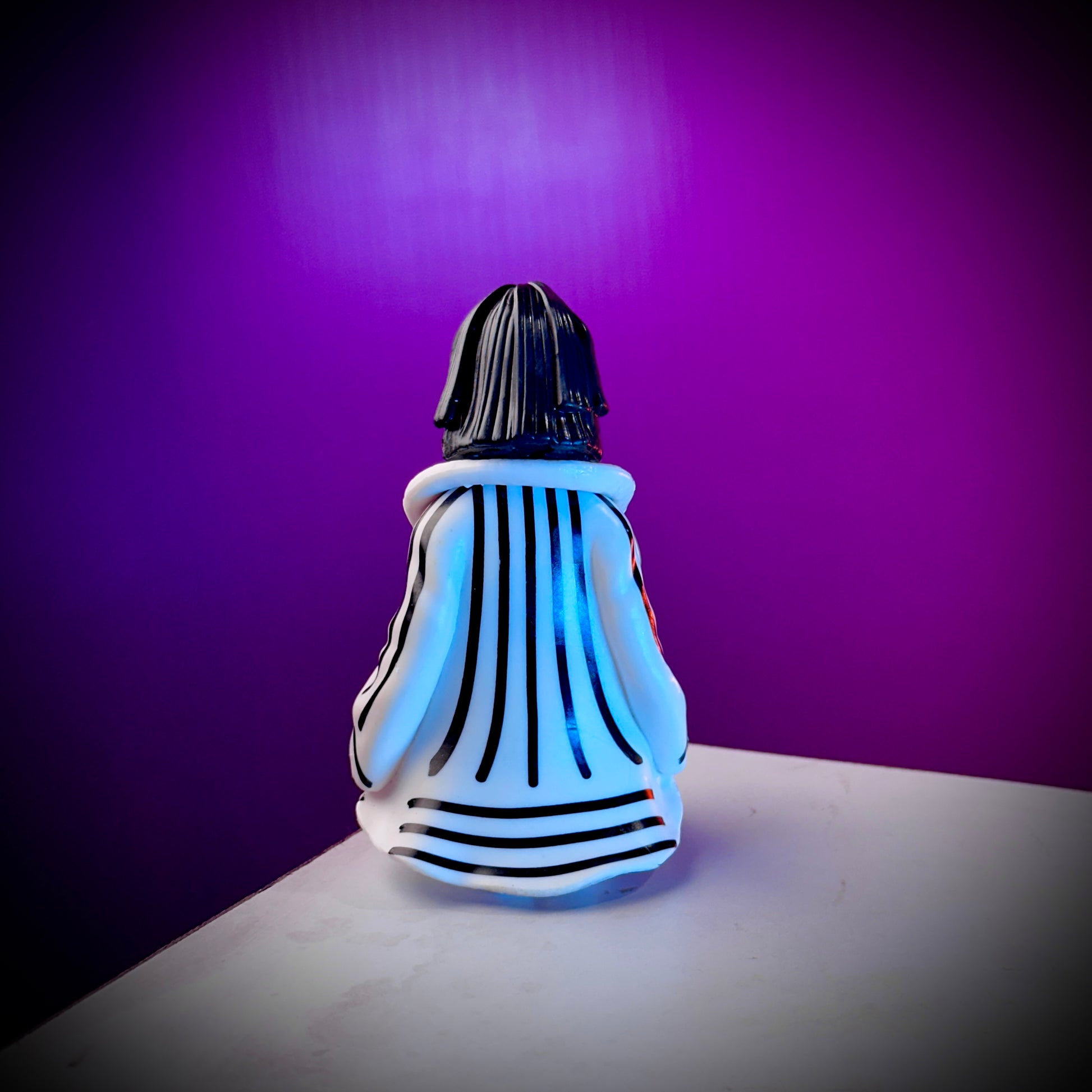 Glass sculpture with black and white striped design on a purple background