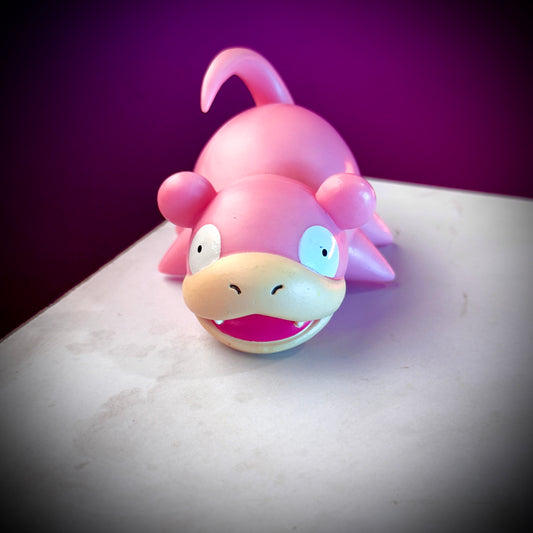 Pink cartoon-like creature on a white surface with a purple background