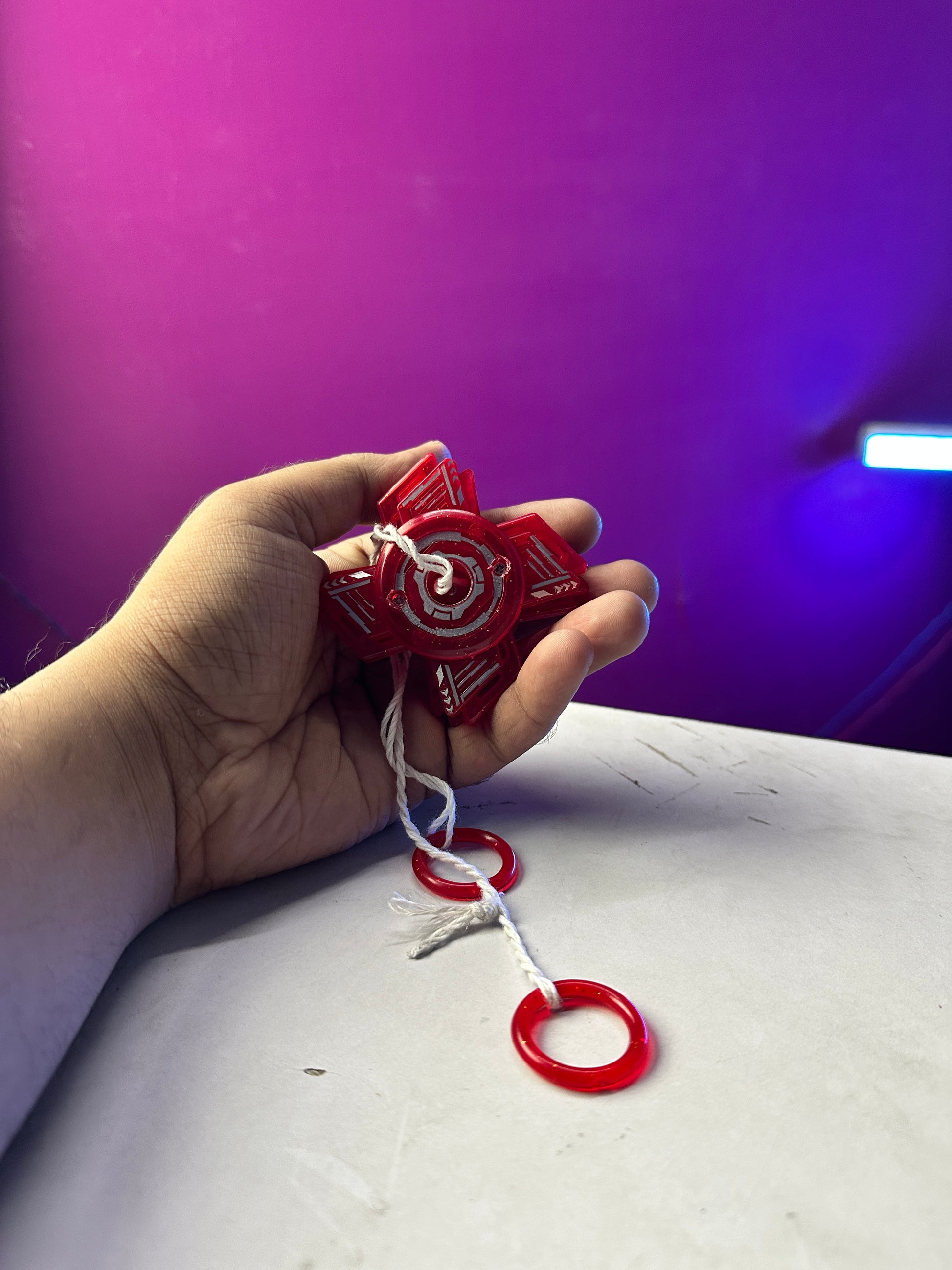 Red sparkling pull string spinner toy