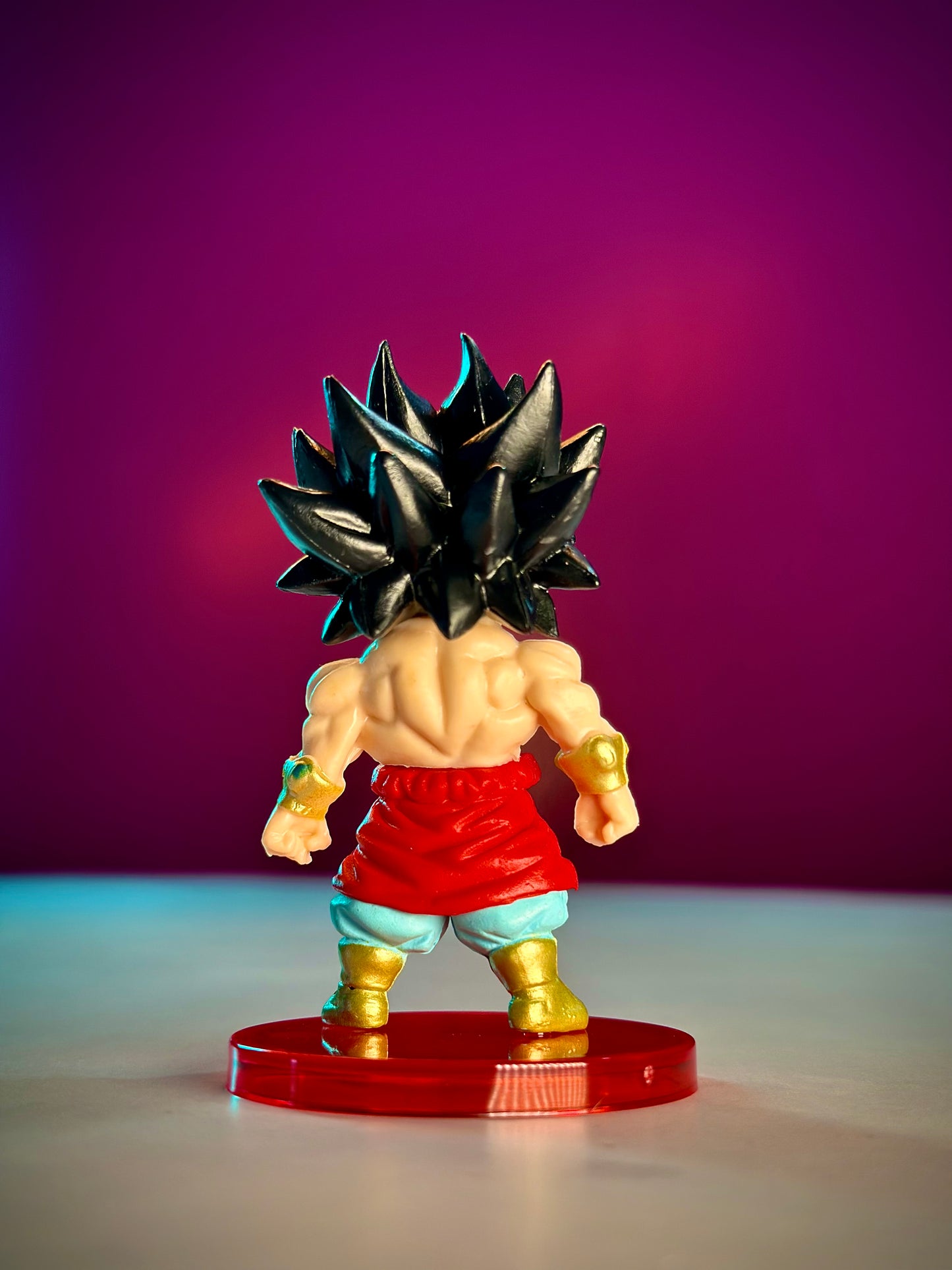 Action figure with spiky hair and red shorts on a purple background