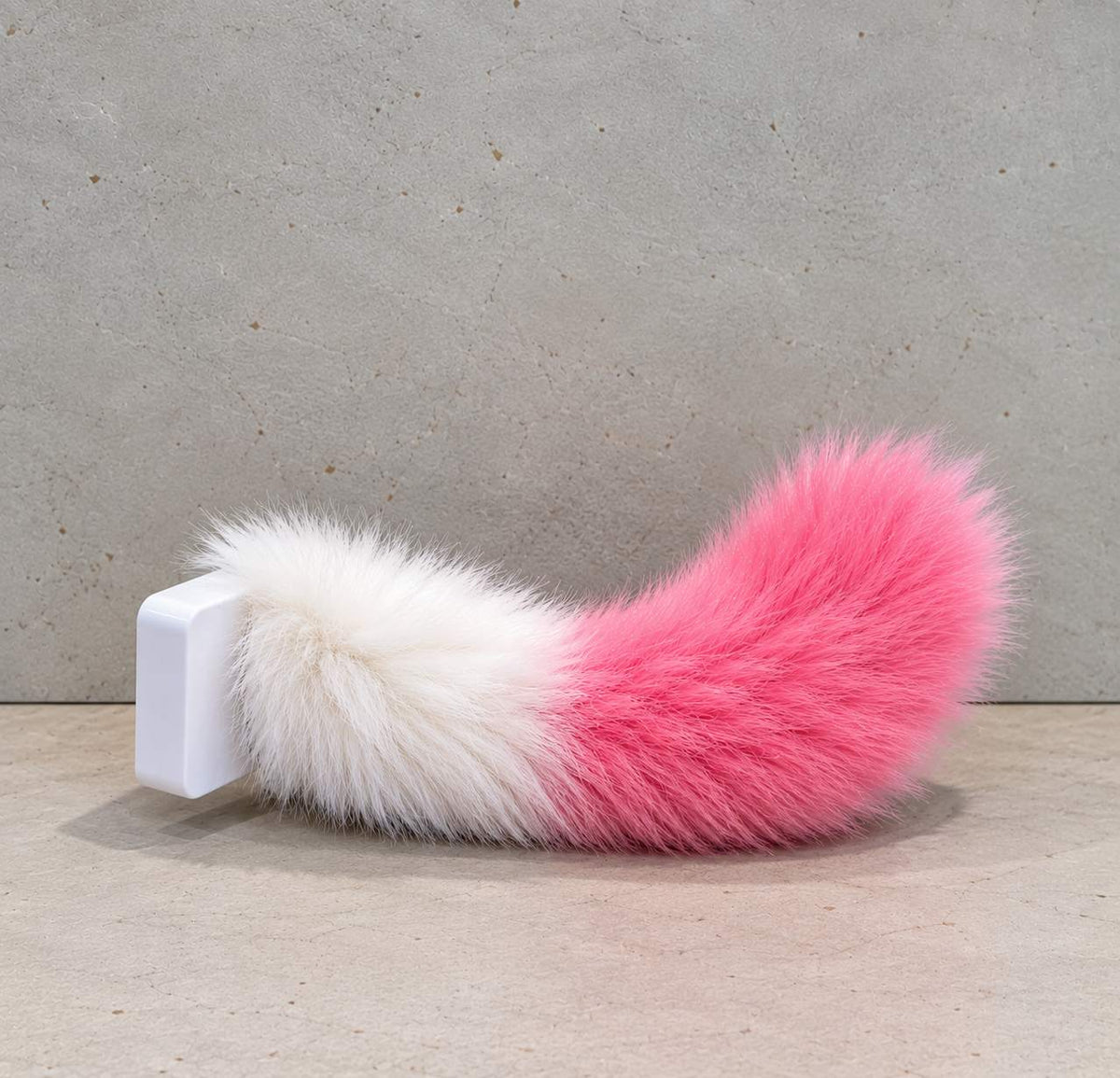 Cute pink and white fluffy wagging tail mounted on a vehicle